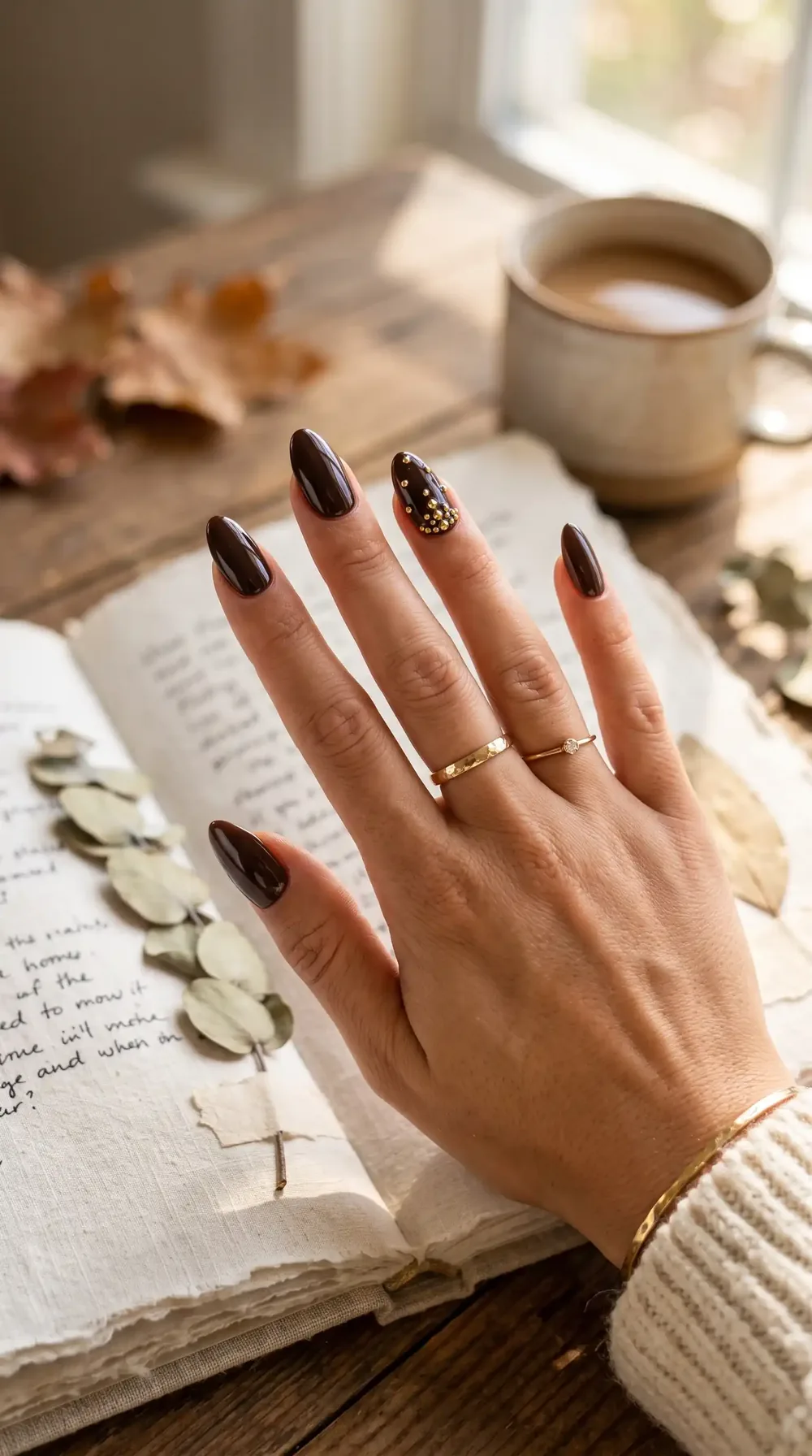 Dark chocolate fall almond nails with small gold stud details Dark chocolate fall almond nails with small gold stud details