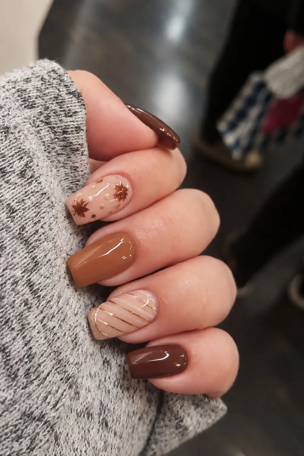 Short caramel and chocolate fall nails with leaf decals and stripes Short caramel and chocolate fall nails with leaf decals and stripes
