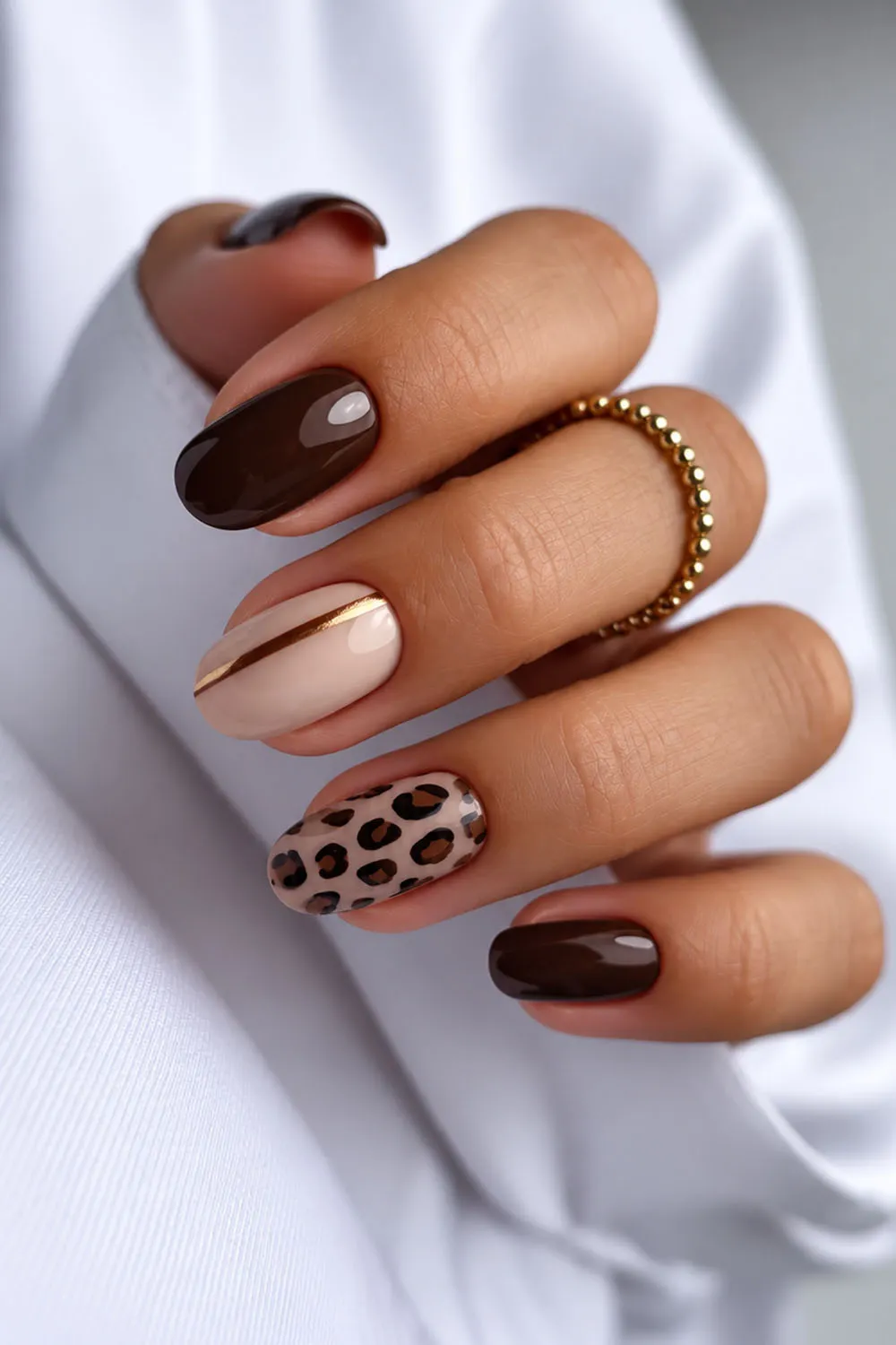 Short chocolate brown fall nails with a leopard print accent nail Short chocolate brown fall nails with a leopard print accent nail