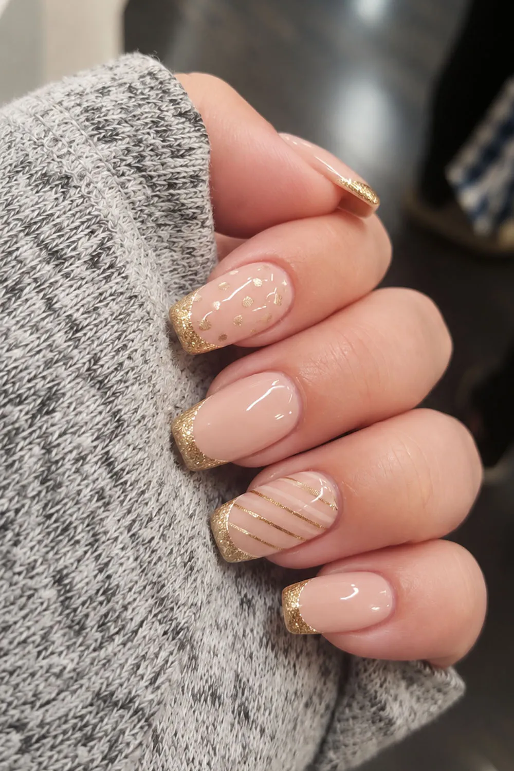 Short nude nails with gold french tips and fine line art details Short nude nails with gold french tips and fine line art details
