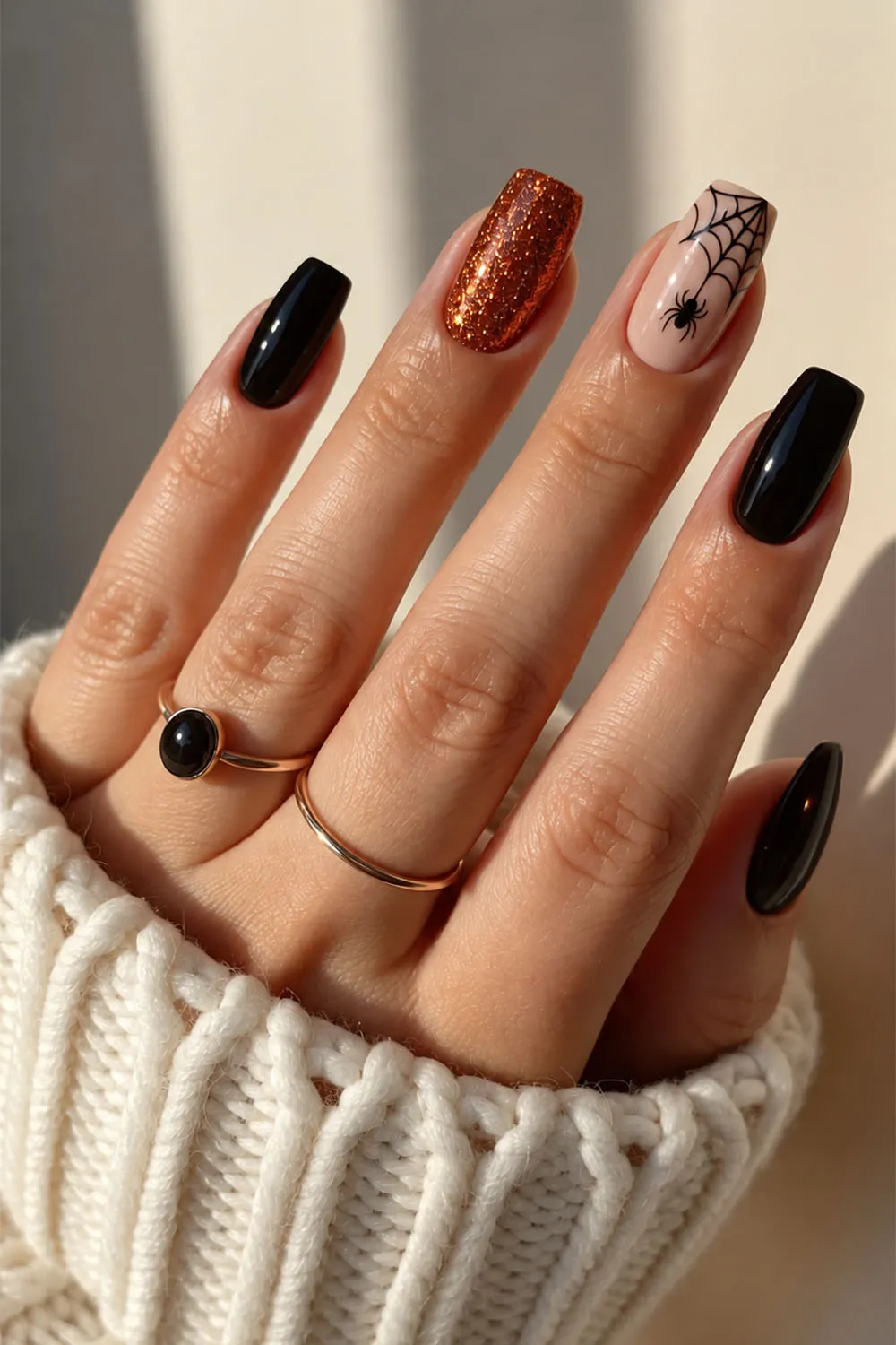 Short halloween nails in black and copper glitter with a spiderweb accent