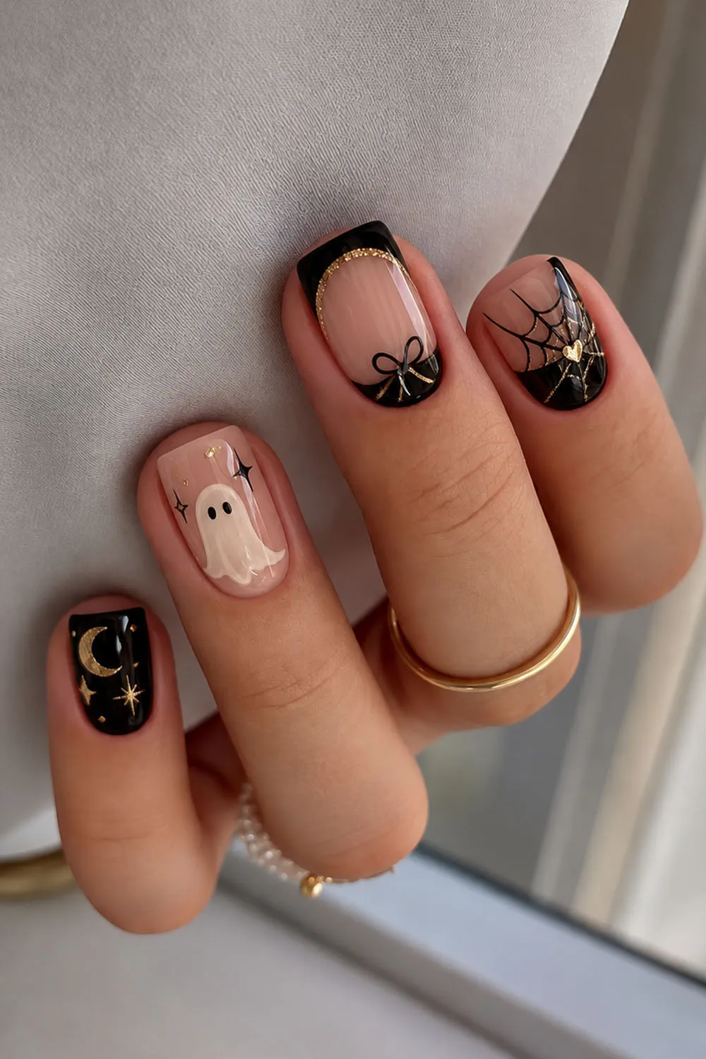 Short halloween nails with bow, ghost and moon details on nude and black