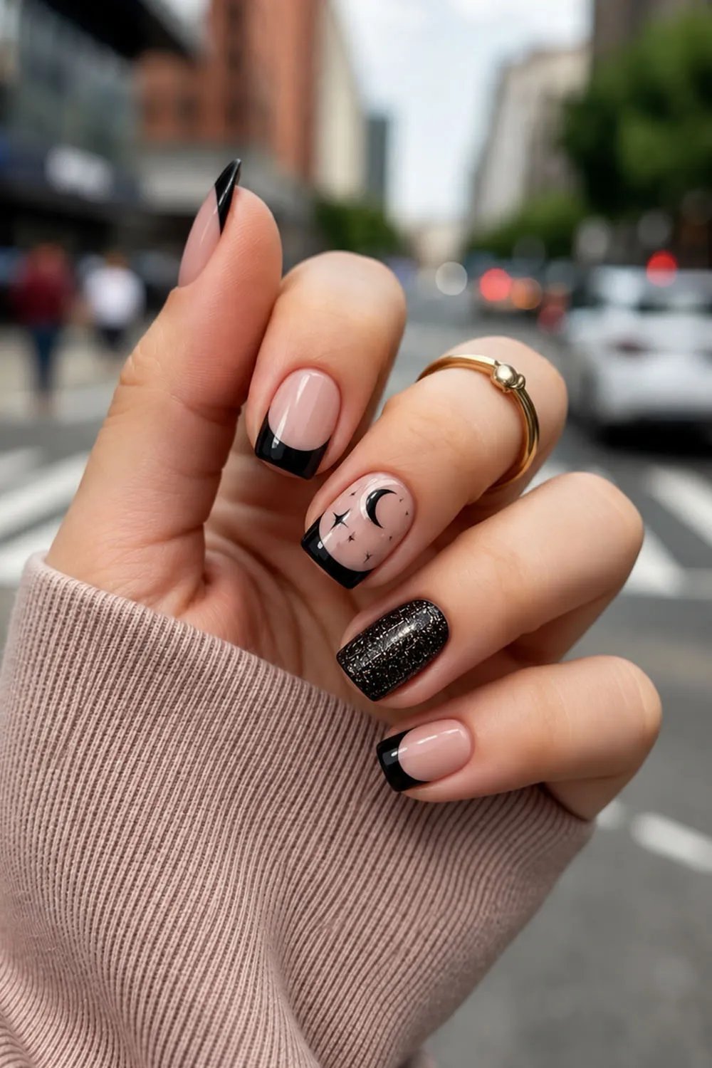 Short halloween nails in nude and black with moon and star accents