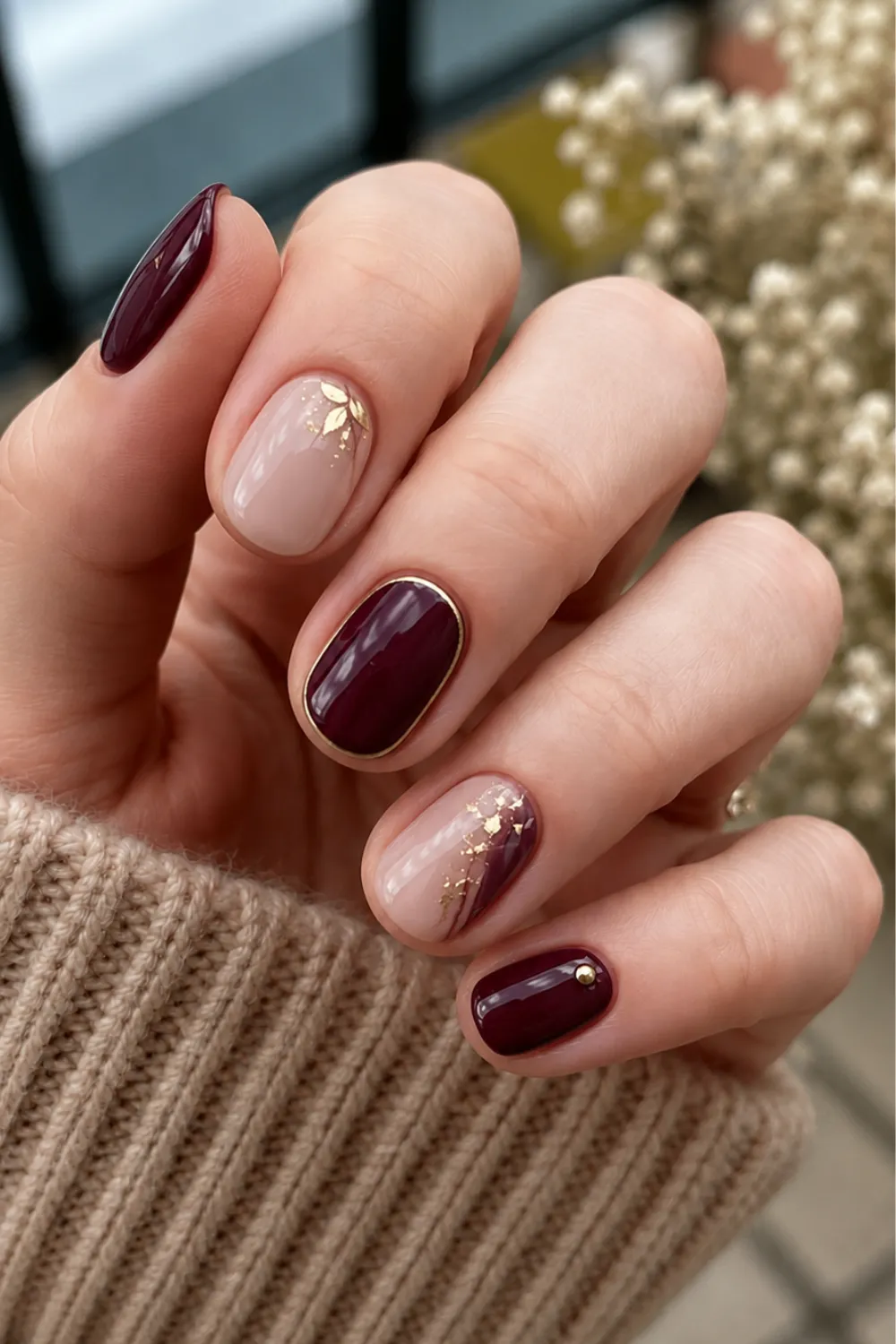 Short burgundy and nude nails with fine gold detailing Short burgundy and nude nails with fine gold detailing